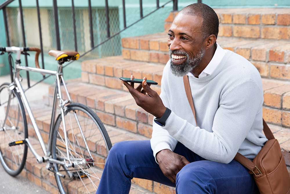 African American man sitting on stairs and having a phone call