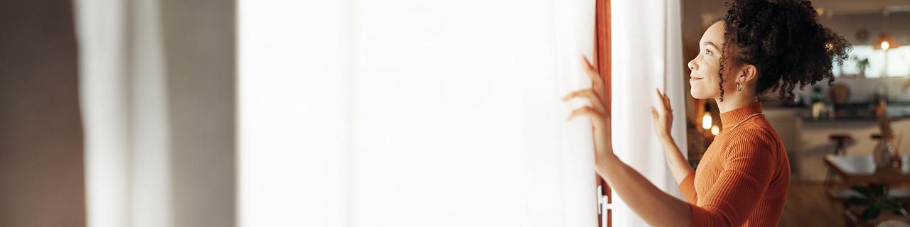 Curtains, happy woman and thinking of future in home, planning and reflection of mindset with view. Window, smile and African girl with vision, ideas and dream for morning inspiration in living room