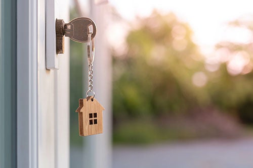 The house key is inserted in front of the door and opens to welcome the new owner. Home selling ideas, home mortgage