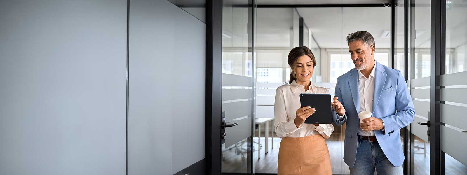 Two busy business man and woman executives team using tablet in office.
