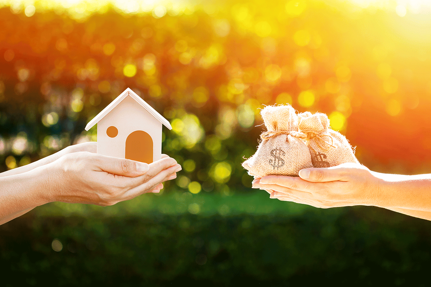 Loan or save for buy a house and real estate concept, Man and women hand holding money bags and a model home put together in the public park.