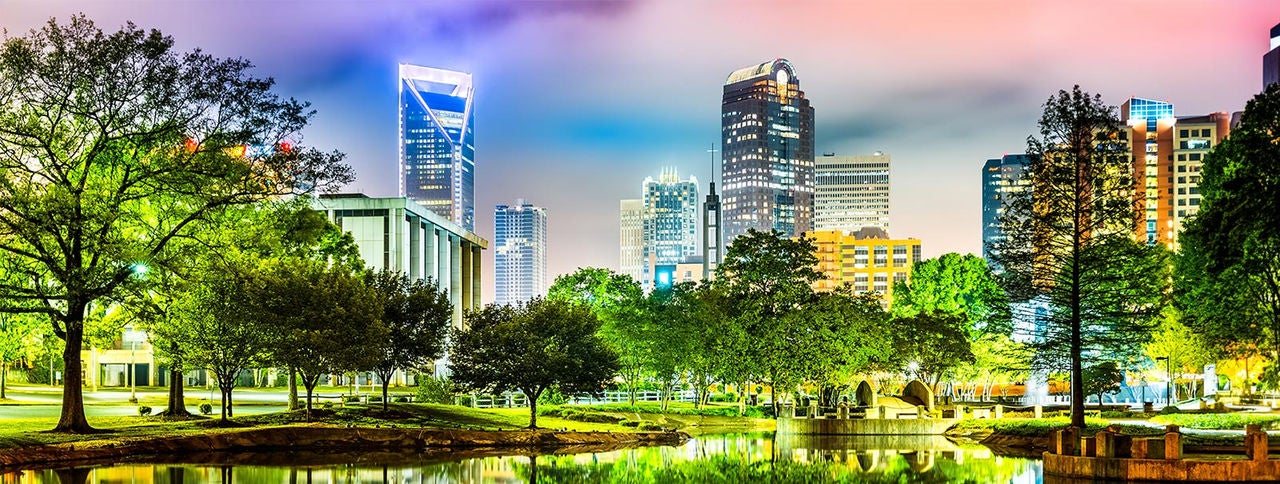 Charlotte, NC skyline reflected in Marshall Park pond on a foggy night
