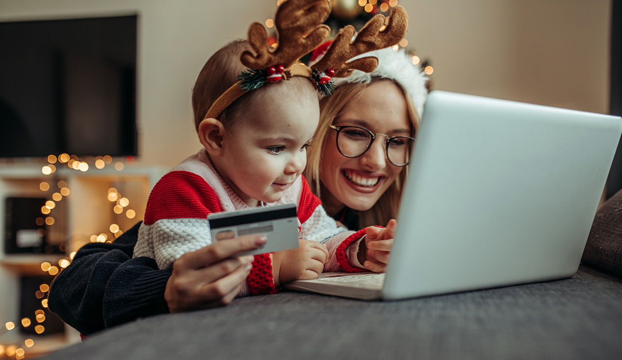 Woman and baby online shopping. Close up of a young woman and her baby buying presents online., Woman and baby online shopping. Close up of a young woman and he