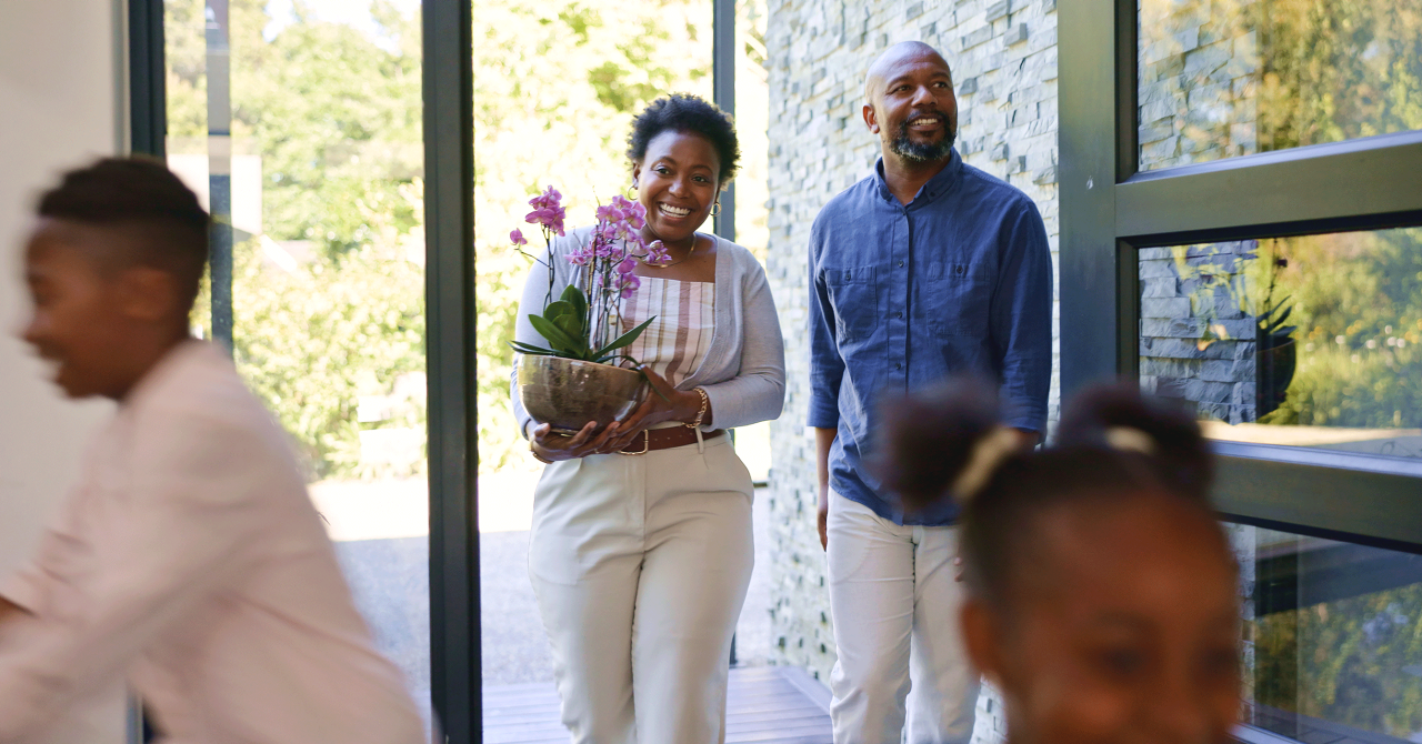 Happy family, children and walk by door in new home in excitement for real estate, property investment or flower plant. Black man, woman and kids with motion blur for relocation, moving or together