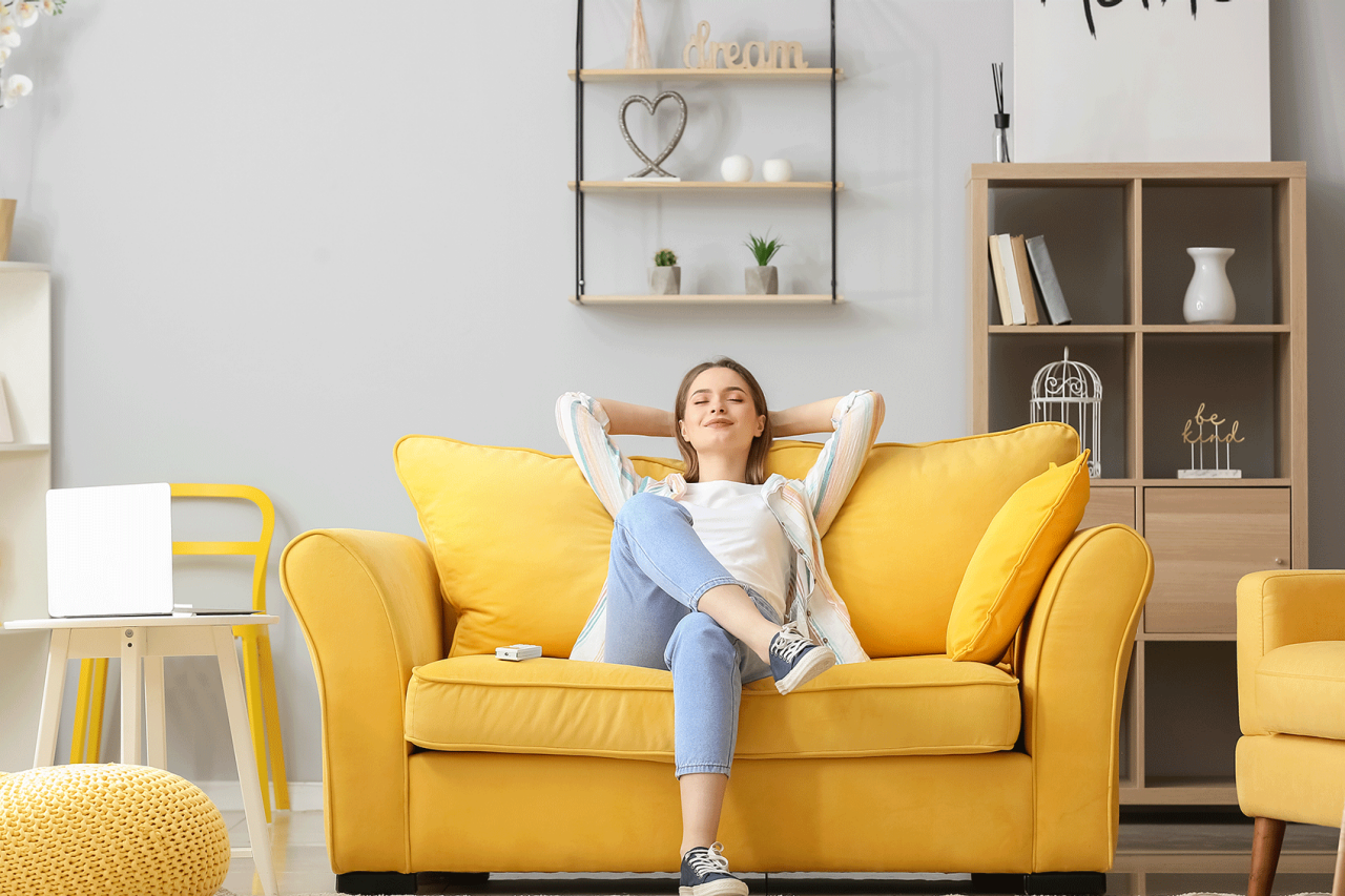 Young woman relaxing on couch feeling relieved